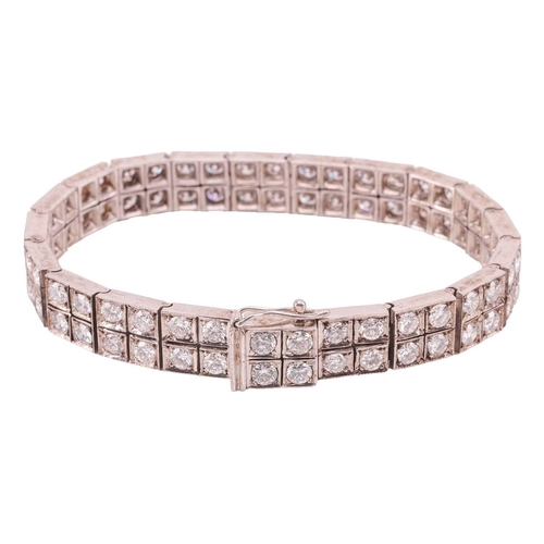 58 - A double-row diamond-set line bracelet, composed of twenty square links, each claw-set with four rou... 