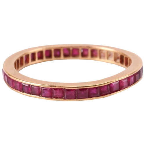 8 - A ruby-set eternity ring, channel-set with calibre-cut rubies, to an unmarked yellow metal mount tes... 