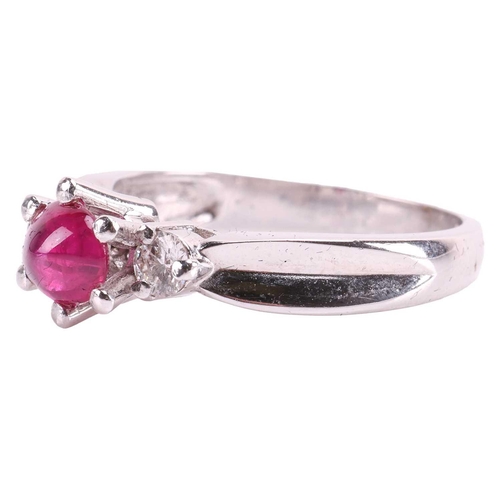 86 - A ruby cabochon and diamond dress ring, centred with an oval ruby cabochon of 5.9 x 5.0 x 2.8 mm, in... 