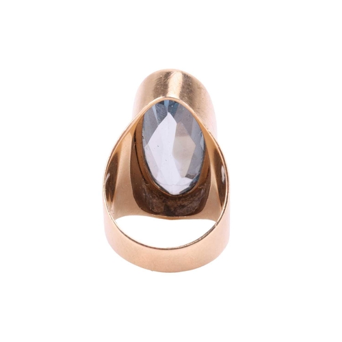 110 - A synthetic spinel cocktail ring in 9ct gold, collet-set with a large and elongated oval-cut light b... 