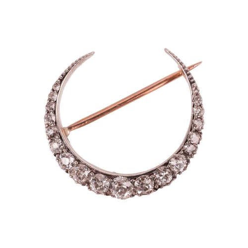 120 - A Victorian diamond-set crescent brooch, set with nineteen old-cut diamonds, the largest measuring a... 