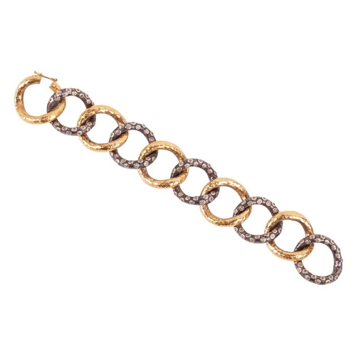 148 - A 'Milkyway' two-tone link bracelet, by Ara Collection, comprising a series of large, hammered curb ... 