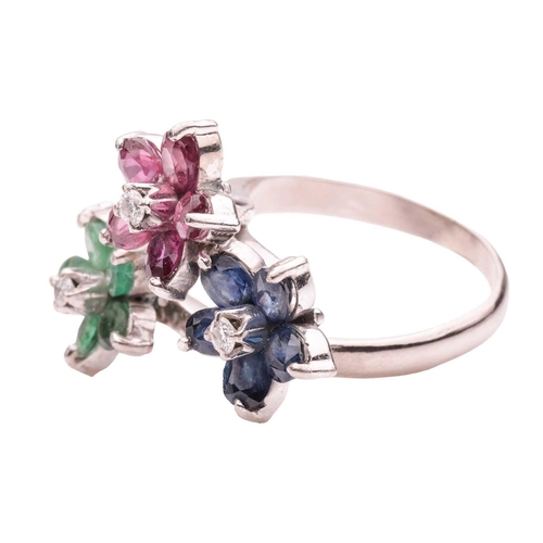 167 - A floral gem-set crossover ring, featuring three staggered flower heads, each set with a round brill... 