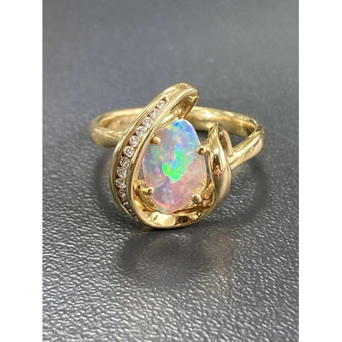 173 - An opal and diamond dress ring, featuring a free-form precious opal slice of 10.1 x 7.0 x 1.1 mm, di... 