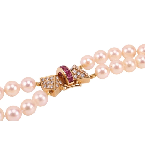 179 - A double-row cultured pearl necklace with a ruby and diamond clasp in 18ct gold, comprising two stra... 