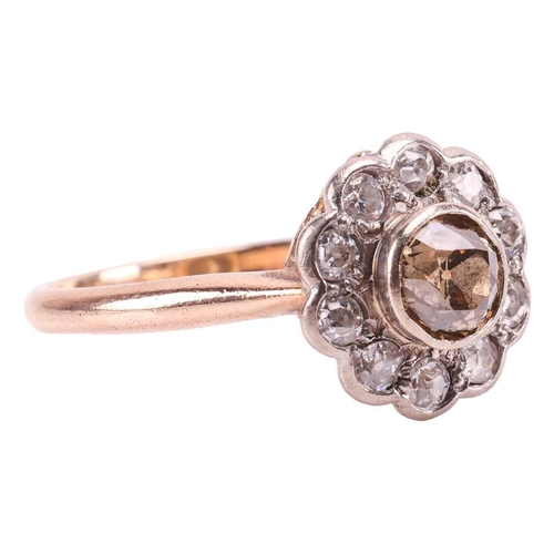 182 - A diamond daisy head cluster ring, featuring a tinted yellowish-brown old-cut diamond of 5.5 mm, col... 