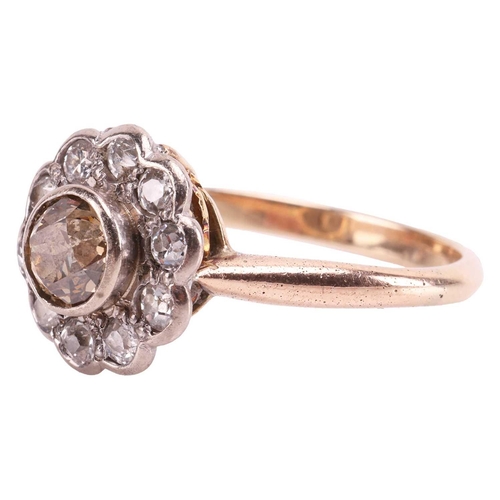 182 - A diamond daisy head cluster ring, featuring a tinted yellowish-brown old-cut diamond of 5.5 mm, col... 