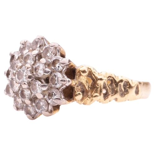 190 - A Modernist-style diamond cluster ring in 18ct gold, set with nineteen round brilliant-cut diamonds,... 