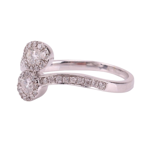 211 - A diamond-set crossover ring, with two connected diamond halos, each featuring a central diamond mea... 