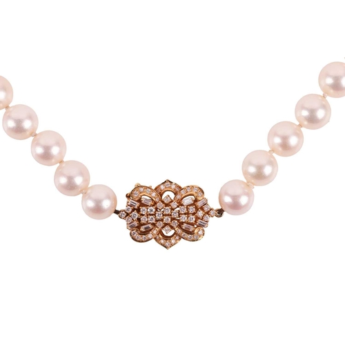 228 - A long cultured pearl necklace with diamond-set clasp, the uniform-size round pearls each measure 9.... 