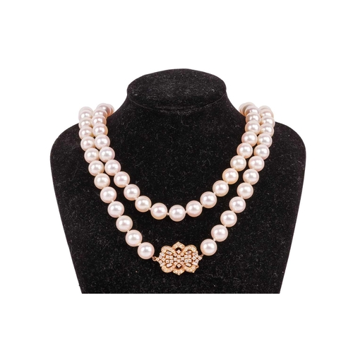 228 - A long cultured pearl necklace with diamond-set clasp, the uniform-size round pearls each measure 9.... 