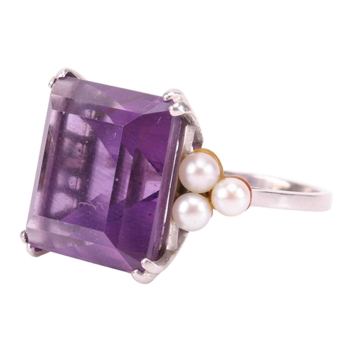 239 - An amethyst and seed pearl dress ring, featuring a step-cut amethyst of 14.0 x 13.2 mm, flanked by t... 