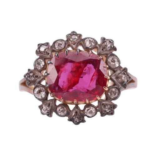 247 - A ruby and diamond cluster ring, centred with an oval-cut ruby of 9.5 x 8.2 x 3.3 mm, within a frame... 