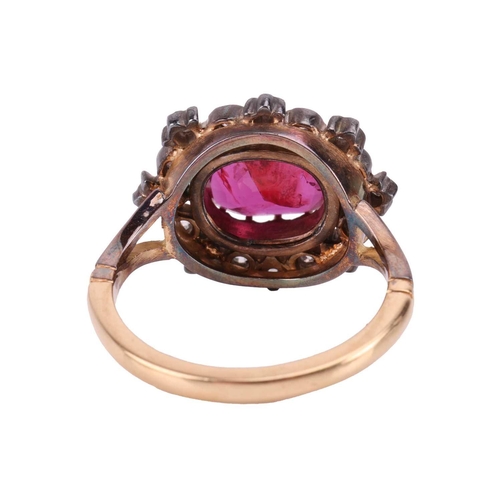 247 - A ruby and diamond cluster ring, centred with an oval-cut ruby of 9.5 x 8.2 x 3.3 mm, within a frame... 