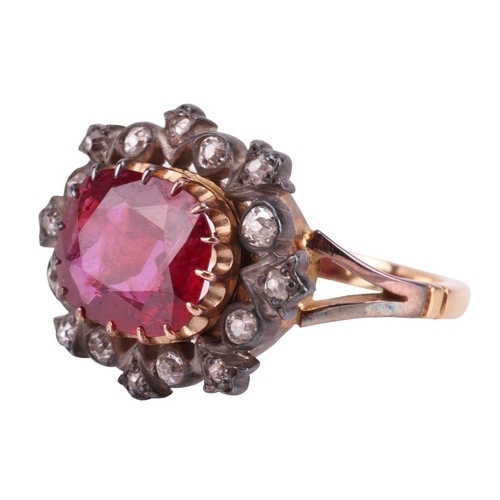 247 - A ruby and diamond cluster ring, centred with an oval-cut ruby of 9.5 x 8.2 x 3.3 mm, within a frame... 