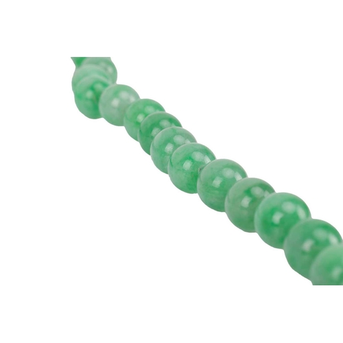 262 - A jade bead necklace with emerald and diamond clasp, circa 1920s, comprising a single row of 108 uni... 