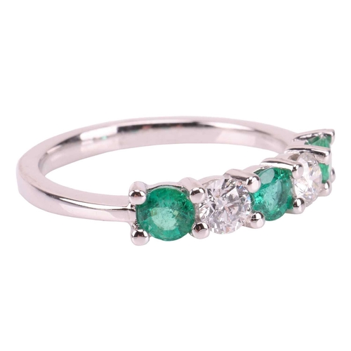 29 - An emerald and diamond-set half-hoop ring, featuring five alternating emeralds and diamonds, measuri... 