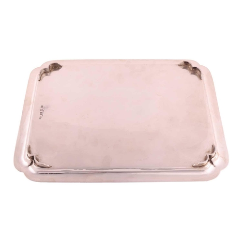 333 - A silver tray with glass liner, rectangular with incuse corners and shaped bracket feet; with plain ... 