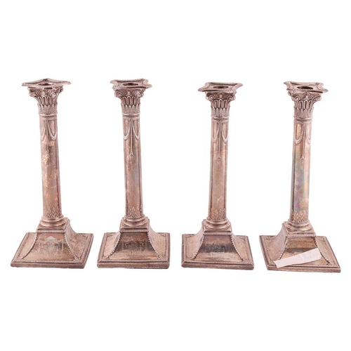 355 - A set of four George III column candlesticks, on spreading square bases, the sockets formed as a cap... 