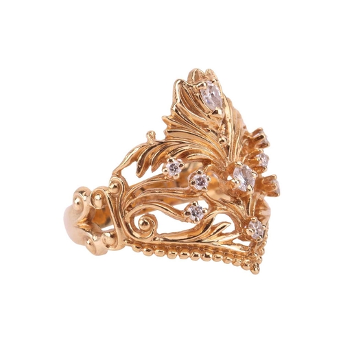 56 - A diamond-set dress ring in 18ct gold, of foliate design, the scrolled openwork mount edged with a g... 