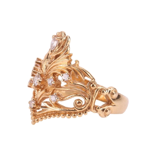 56 - A diamond-set dress ring in 18ct gold, of foliate design, the scrolled openwork mount edged with a g... 