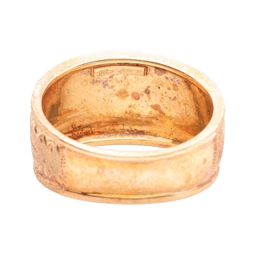 62 - A dress ring of tapered and textured design, overlaid to the front with three starbursts, between re... 