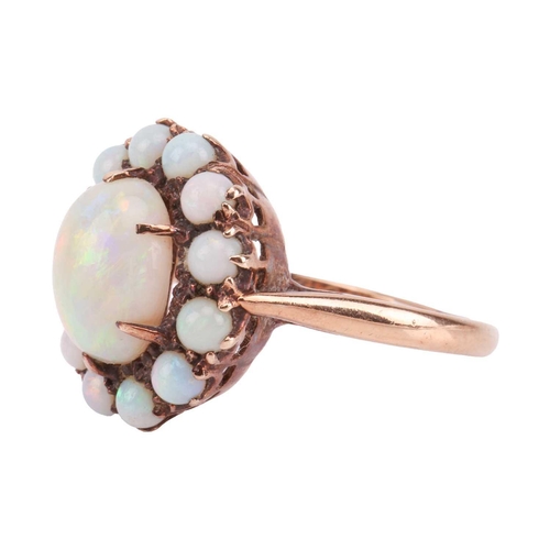 78 - An opal cluster ring, comprising an oval cabochon of a precious opal with vivid spectral play-of-col... 