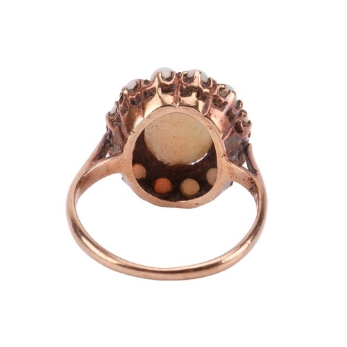 78 - An opal cluster ring, comprising an oval cabochon of a precious opal with vivid spectral play-of-col... 