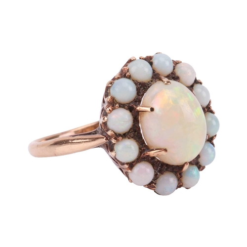 78 - An opal cluster ring, comprising an oval cabochon of a precious opal with vivid spectral play-of-col... 