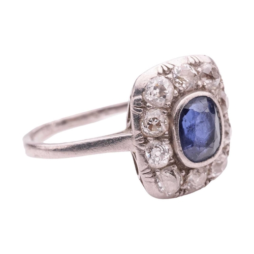 84 - A sapphire and diamond panel ring, the cushion-shaped ring head centred with an oval-cut sapphire of... 