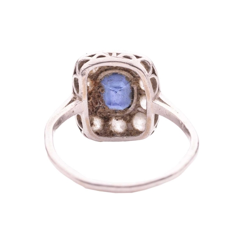 84 - A sapphire and diamond panel ring, the cushion-shaped ring head centred with an oval-cut sapphire of... 