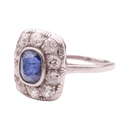 84 - A sapphire and diamond panel ring, the cushion-shaped ring head centred with an oval-cut sapphire of... 