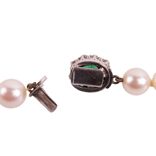 88 - A cultured pearl necklace, the pearls measuring approximately 6mm-7.7mm, leading to a cabochon emera... 