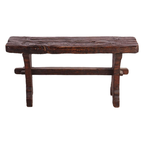 117 - A primitive vernacular oak/elm form stool, 19th century, with thick knarled rectangular top over a b... 