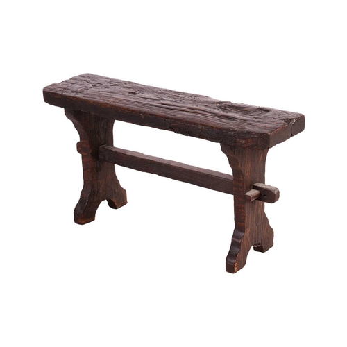 117 - A primitive vernacular oak/elm form stool, 19th century, with thick knarled rectangular top over a b... 