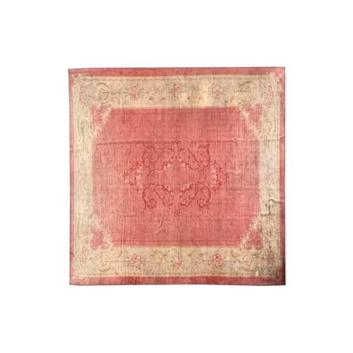 142 - A muted red/pink ground Austrian Savonerie style, neo-classical carpet, C1900, with a large subtle c... 