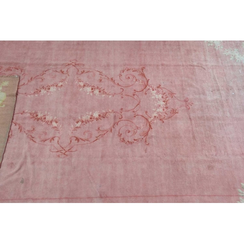 142 - A muted red/pink ground Austrian Savonerie style, neo-classical carpet, C1900, with a large subtle c... 