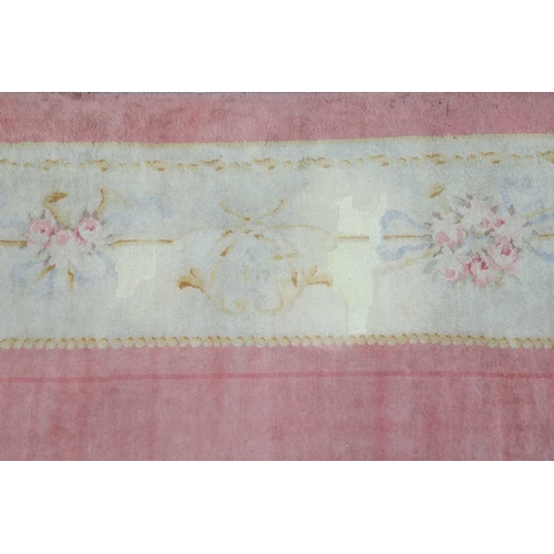 142 - A muted red/pink ground Austrian Savonerie style, neo-classical carpet, C1900, with a large subtle c... 