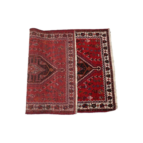 145 - A red ground Qashqai rug with two diamond lozenges on a central pole within multiple borders.170 cm ... 