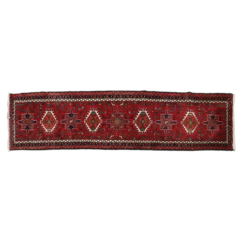 147 - A red ground Karaja strip runner with nice lozenges on a central pole, within multiple borders, 295c... 