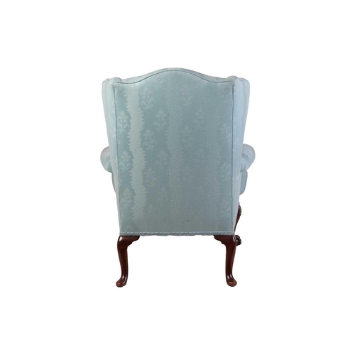 96 - A well-drawn George II-style mahogany wingback armchair. with roll-over arms, upholstered in aqua bl... 