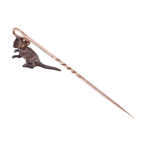 15 - An Edwardian gem-set cat stick pin, the shepherd's crook pin stem dangling a sculpted cat being pick... 