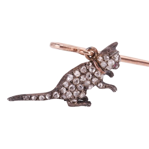 15 - An Edwardian gem-set cat stick pin, the shepherd's crook pin stem dangling a sculpted cat being pick... 