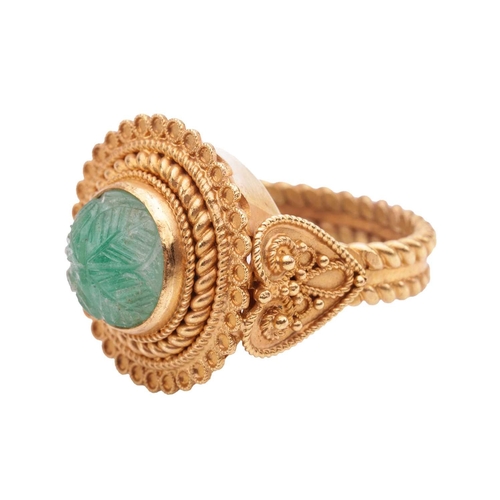 20 - An Etruscan Revival ring set with a carved emerald, the round emerald cabochon of 8.8 x 8.8 x 6.4 mm... 