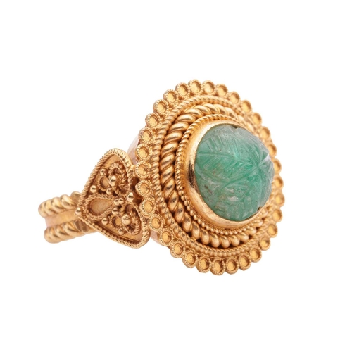 20 - An Etruscan Revival ring set with a carved emerald, the round emerald cabochon of 8.8 x 8.8 x 6.4 mm... 