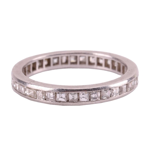 22 - A diamond-set eternity ring, featuring a single row of channel-set diamonds, with a mix of table-cut... 