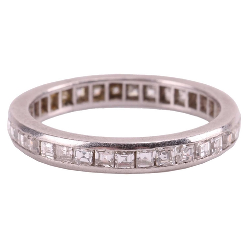 22 - A diamond-set eternity ring, featuring a single row of channel-set diamonds, with a mix of table-cut... 