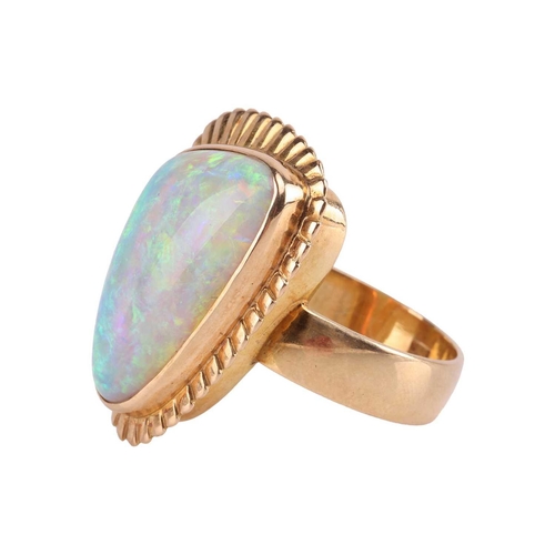 3 - A large opal cocktail ring, the gadrooned triangular head collet-set with a free-formed polished pre... 