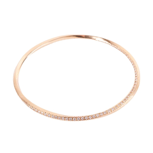 32 - A diamond-set closed bangle, of twist design, pavé-set with an array of brilliant-cut diamond accent... 