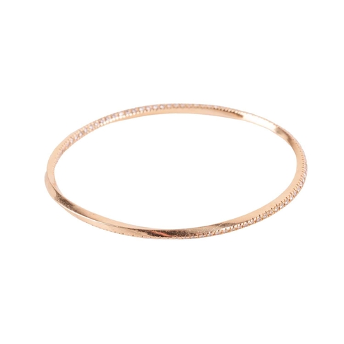 32 - A diamond-set closed bangle, of twist design, pavé-set with an array of brilliant-cut diamond accent... 